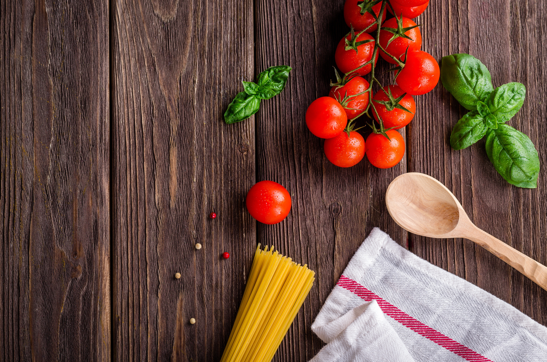 Top view of Spaghetti, Tomatoes and Basil on a Wooden Background